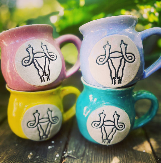  A colorful ceramic mug with a vibrant uterus design, advocating for feminism and gender equality.
