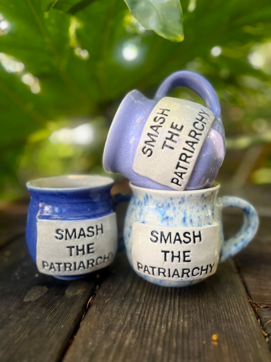  A ceramic coffee mug featuring the bold phrase ‘Smash the Patriarchy,’ symbolizing a call for gender equality and social change